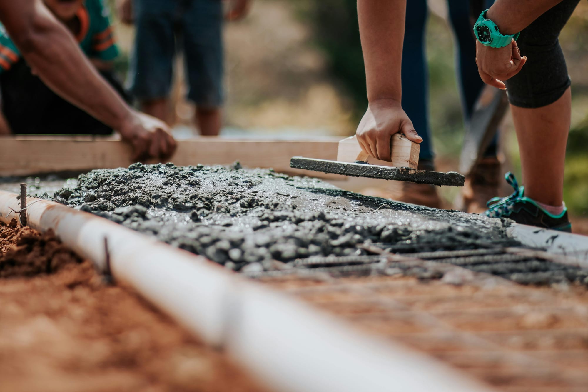 Workers lay wet cement.