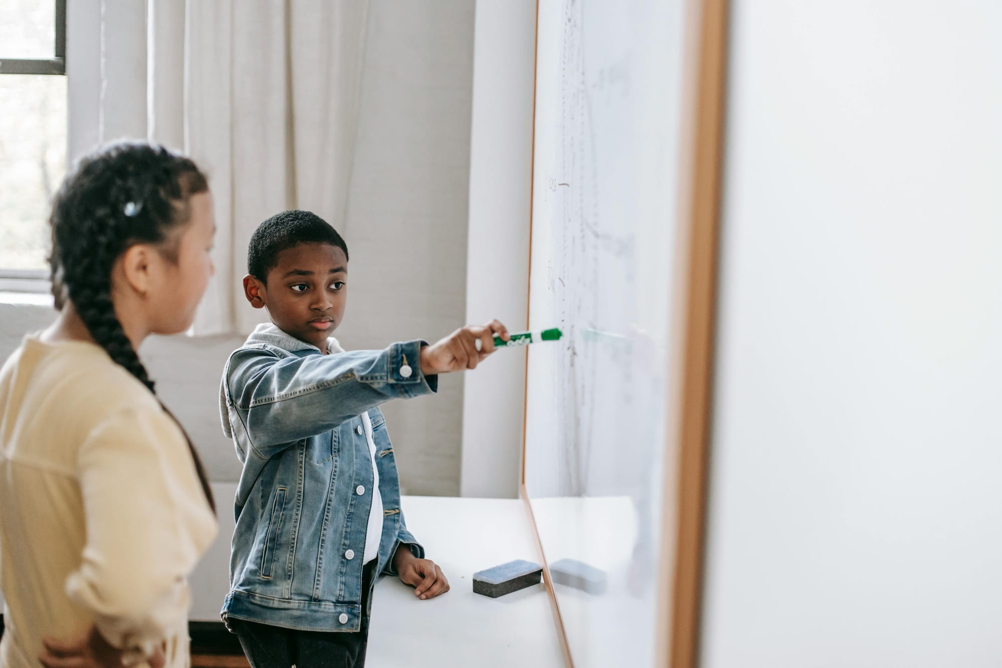 students pointing at white board