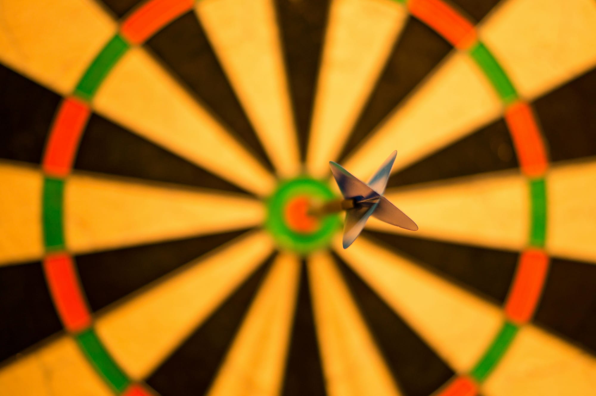 A dart flies toward the bullseye on a dart board.