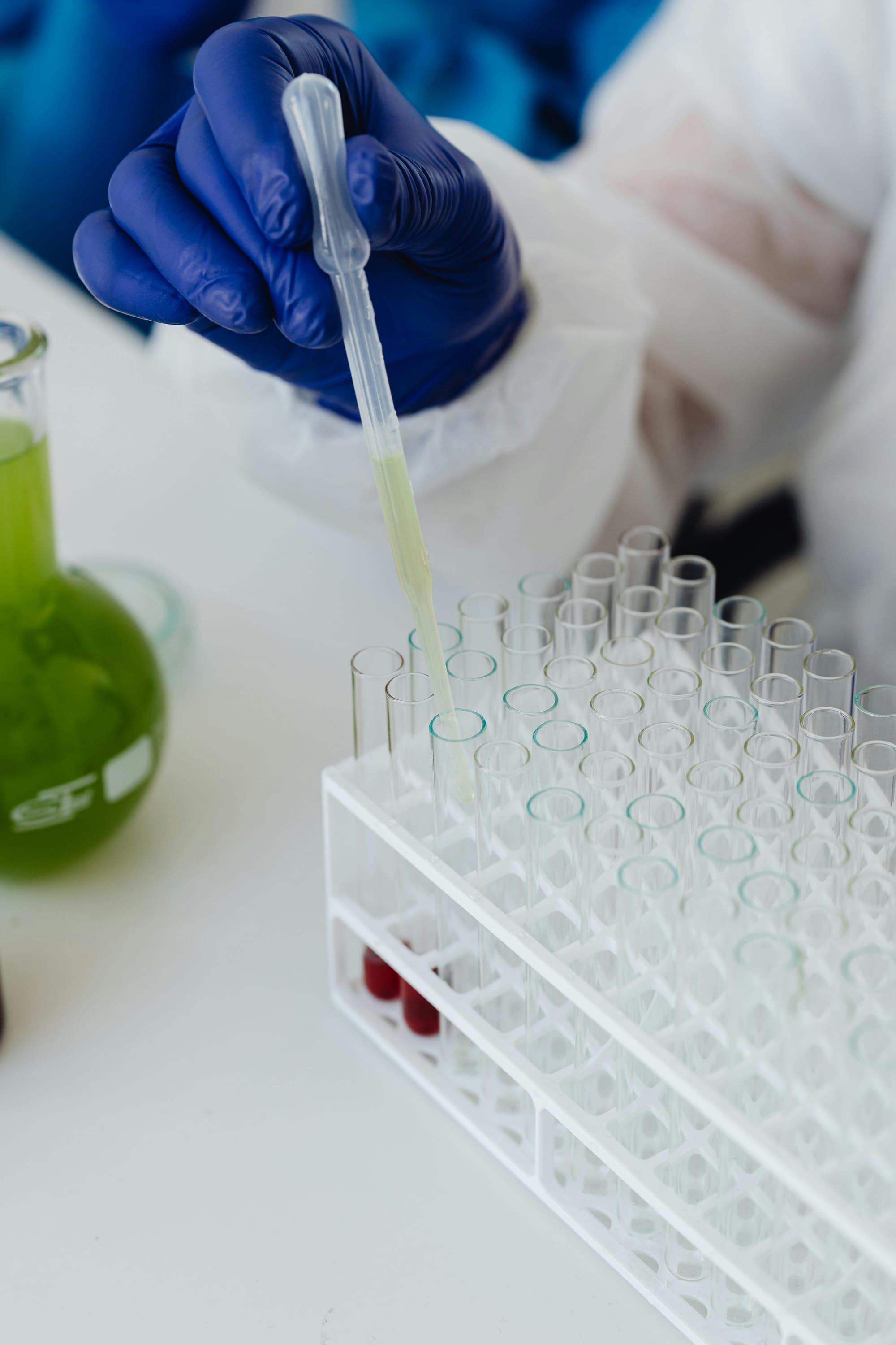 Close up of scientist's hands piping liquid into vials.