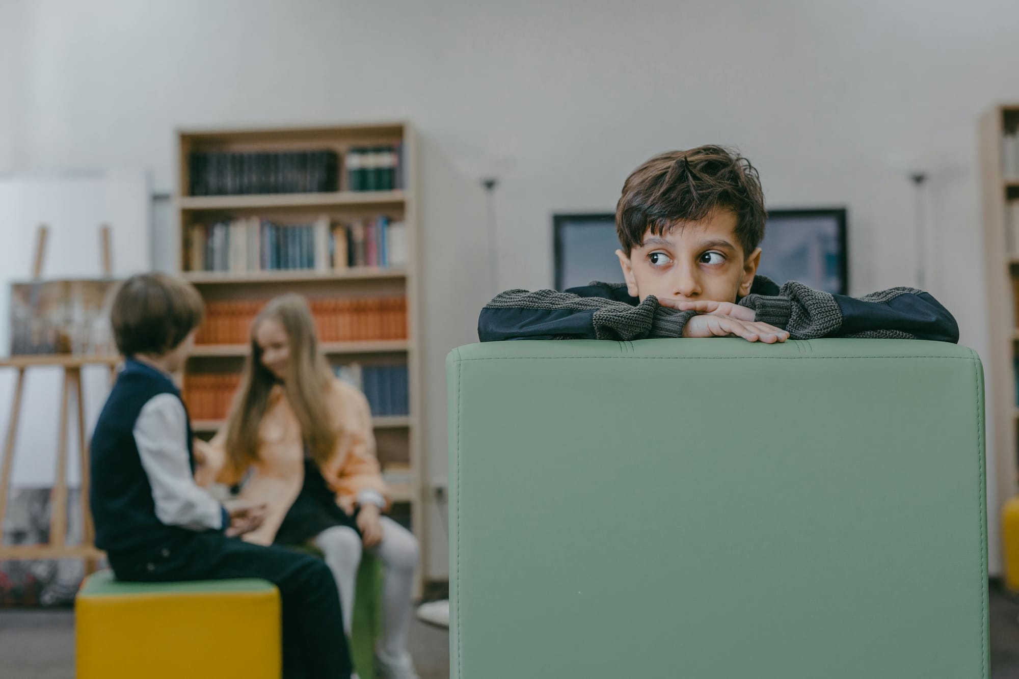 Kid Sitting Alone while Other Children Play Together