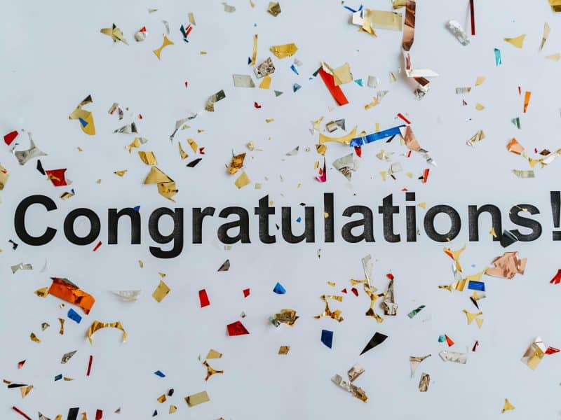 The word congratulations on a white background with confetti