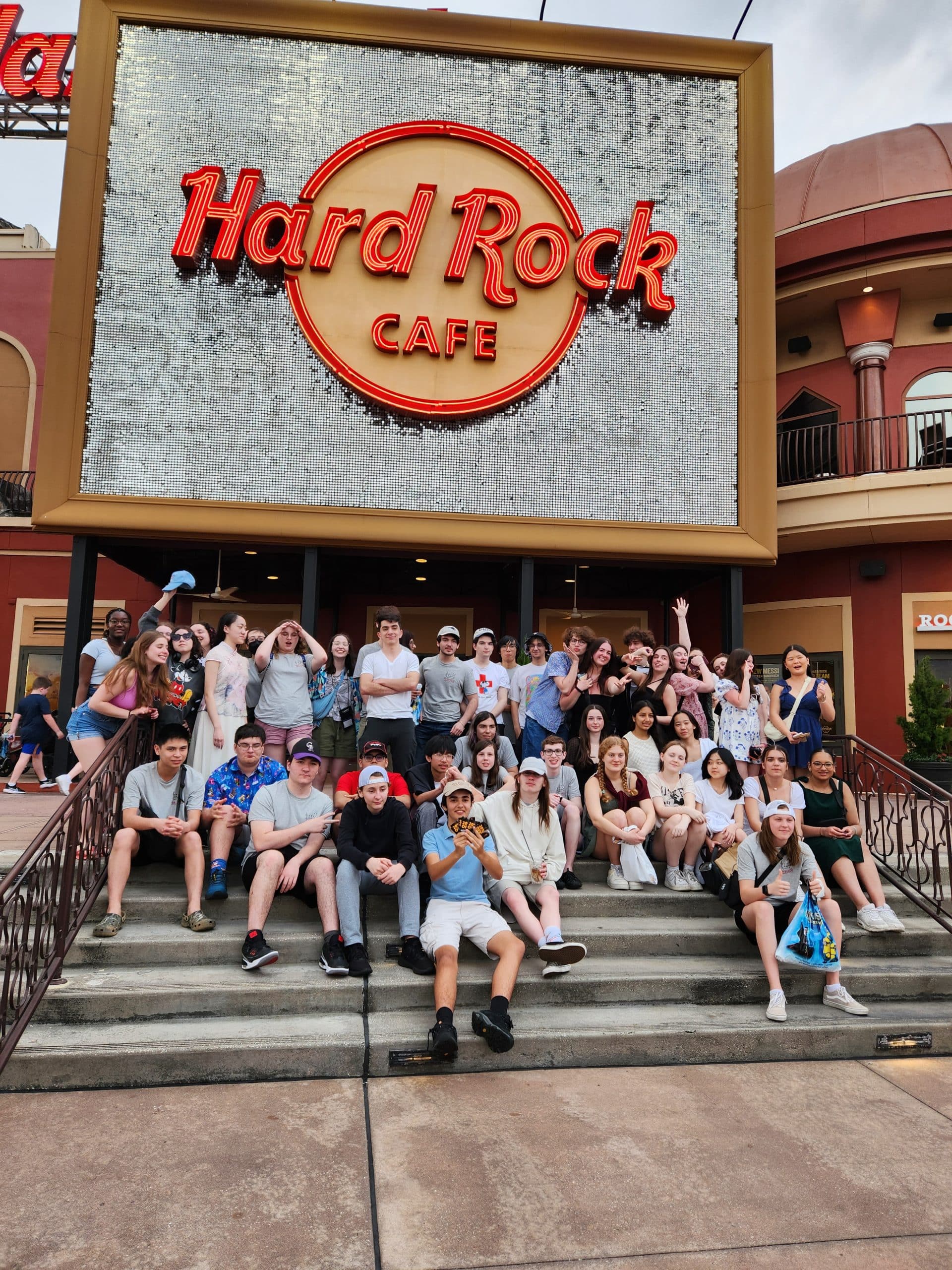 BHS Chorus and Orchestra sit on the steps of Hard Rock Cafe